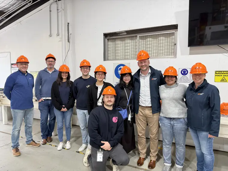 A group wearing orange hard hats on a site visit